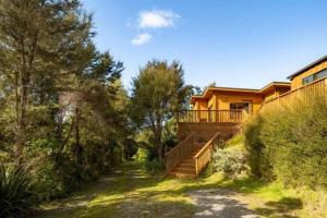 a house with a staircase leading up to a house at Absolute Tranquility - surrounded by native bush in Kaiuma