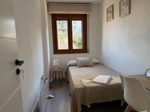 a small bedroom with a bed and a window at Rubín 21 in Redondela