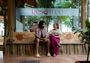 a man and a woman sitting on a bench in front of arescue at Resotree in Talai