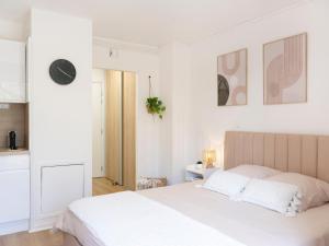 a white bedroom with a large bed with white sheets at Le doux refuge domaine thermal et activités touristiques Amnéville in Amnéville