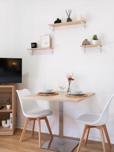 a dining room table with white chairs and shelves at Le doux refuge domaine thermal et activités touristiques Amnéville in Amnéville