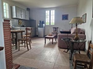 a kitchen and living room with a couch and a table at domaine des trois rivières in Sainte-Marguerite-de-Viette