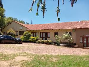 a house with a car parked in front of it at Cozy guestrooms in Midrand in Midrand