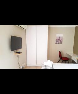 a room with a tv and a table and a chair at Cozy guestrooms in Midrand in Midrand