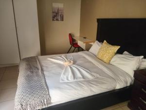 a bedroom with a bed with a robe on it at Cozy guestrooms in Midrand in Midrand
