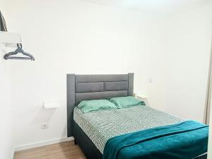 a bedroom with a bed with a blue blanket on it at Casa das Cachoeiras in Botucatu