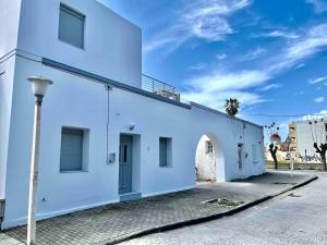 a white building with a street light next to it at Nóstos Home in Kos