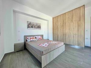 a bedroom with a bed and a wooden wall at Nóstos Home in Kos