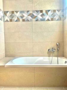a bath tub with a faucet in a bathroom at Nóstos Home in Kos +14 photos