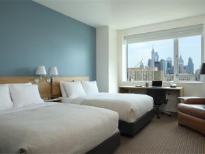 a hotel room with two beds and a desk and a window at The Study at University City in Philadelphia +40 photos