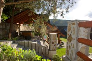 a garden with a stone fence and a house at Dolina Popradu Apartments in Muszyna
