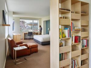 a hotel room with a bed and a book shelf at The Study at University City in Philadelphia