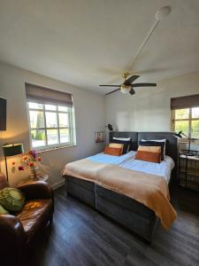a bedroom with a large bed and a couch at 't Rheebokje in Uddel