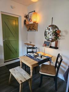 a room with a green door and a table and chairs at 't Rheebokje in Uddel