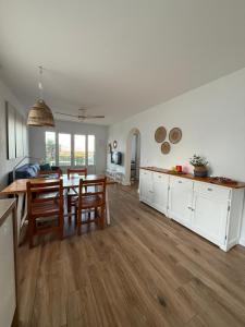 a kitchen and living room with a table and chairs at Ca la Marta apartamento con piscina y jardín a 150m de la playa in Arenal d'en Castell
