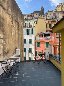 a patio with tables and chairs on a balcony at Cà Della Valletta in Riomaggiore