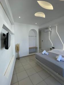a bedroom with a bed and a flat screen tv at Fira centerline Prestige suites in Fira