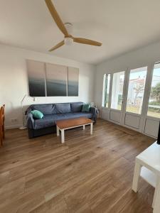 a living room with a couch and a ceiling fan at Ca la Marta apartamento con piscina y jardín a 150m de la playa in Arenal d'en Castell