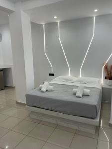 a white bedroom with a bed with two pillows at Fira centerline Prestige suites in Fira