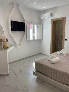 a bedroom with a bed and a flat screen tv at Fira centerline Prestige suites in Fira