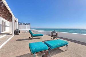 a patio with chairs and the ocean in the background at Luxury & Spacious Beachfront Home Casa Espiritu in Puerto Peñasco
