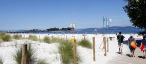a group of people walking on a beach at PENSION LUCERNA in Vigo +6 photos