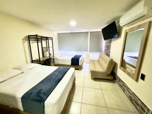 a hotel room with a large bed and a couch at Hotel Estadio 80 in Medellín