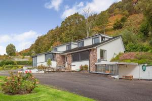 a large white house with a hill in the background at 3 Bed in Ullapool oc-s33063 in Ullapool