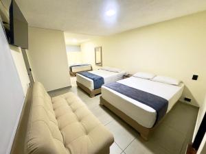 a hotel room with two beds and a couch at Hotel Estadio 80 in Medellín +64 photos