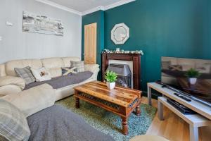 a living room with a couch and a tv at Mar Apartment in Stirling
