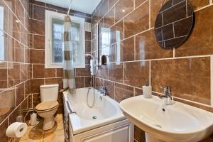 a bathroom with a sink and a toilet and a mirror at Mar Apartment in Stirling +20 photos