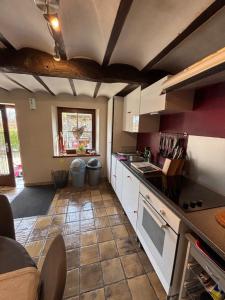 a kitchen with white cabinets and a tile floor at La Petite maison in Montleban