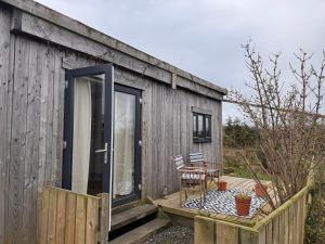 a wooden cabin with a table and chairs on a deck at Vinnies hideaway in Morpeth