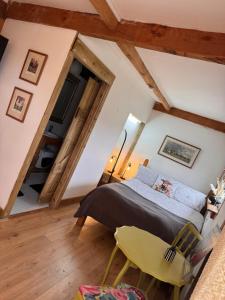 a bedroom with a bed and a yellow chair at Vinnies hideaway in Morpeth