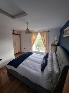 a bedroom with a large bed and a window at Lancaster Cottage in Hawes