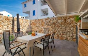 a table and chairs on a patio with a stone wall at Cres Sea & Sunset View in Cres