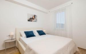a white bedroom with a bed and a window at Cres Sea & Sunset View in Cres