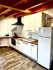 a kitchen with a white refrigerator and a sink at La Lechería de Daniela in Granja de Moreruela