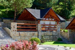 a house with a slate roof and a stone wall at Dolina Popradu Apartments in Muszyna +32 photos