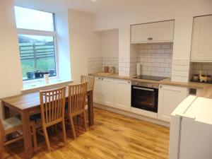 a kitchen with a table and chairs and a window at Lancaster Cottage in Hawes