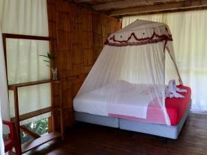 a bed with a canopy in a room with windows at Sinchi Warmi Amazon Lodge in Puerto Misahuallí
