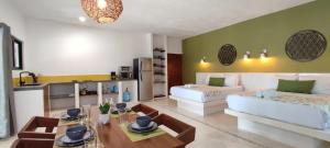 ein Zimmer mit zwei Betten, einem Tisch und einer Küche in der Unterkunft Valentina Holbox by Las Flores Vacation Rentals in Holbox