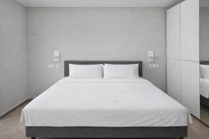 a bedroom with a large bed with white sheets at The Opal - V3 in Valletta