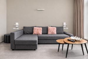 a living room with a gray couch and a table at The Opal - V3 in Valletta