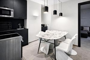 a kitchen with a white table and white chairs at The Opal - V3 in Valletta