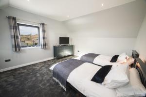 a hotel room with two beds and a window at Taigh Rona in Tarbert