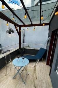 a table and chairs on a balcony with lights at RCM Vilas - Casa Descolada in Joinville