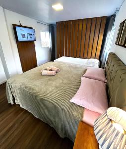 a bedroom with a bed with two stuffed animals on it at RCM Vilas - Casa Descolada in Joinville