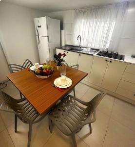 a kitchen with a table with a bowl of fruit on it at RCM Vilas - Casa Descolada in Joinville
