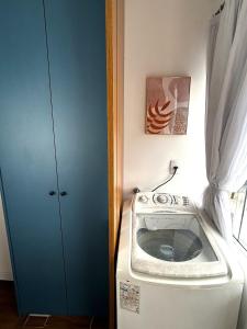 a washing machine in a room with a blue door at RCM Vilas - Casa Descolada in Joinville